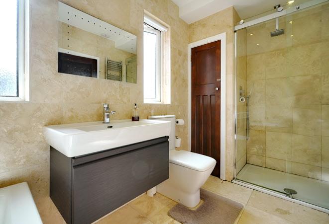 LUXURY WHITE BATHROOM SUITE: Tiled panelled bath with central mixer tap and telephone hand shower, low flush wc,