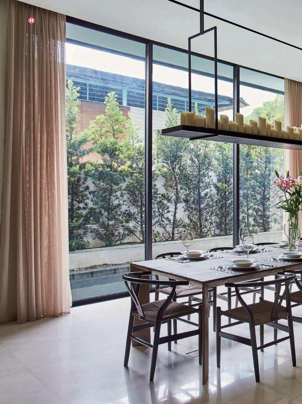 Furnished with fl oor-to-ceiling glass walls and doors, the dining area is a space