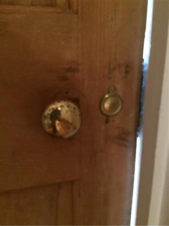 Brass effect door knob and escutcheon. Metal hook on frame.