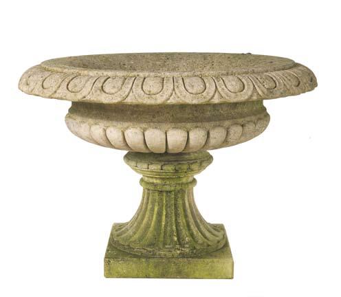 The Tazza Urn [item 49] An elegant hand carved natural limestone Tazza Urn having egg and dart carved rim, lobed body with a ribbed foot and