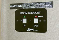 Rear slideout switches (if equipped) are located on a wall in the rear of the coach in or near the slide room. Location varies by model and floorplan.