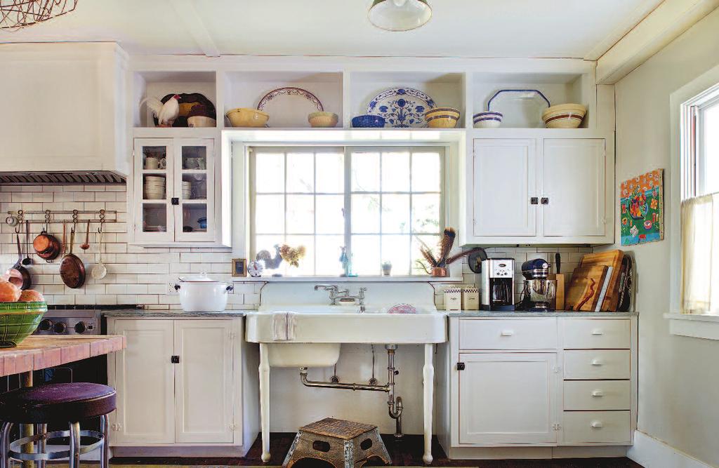 The country-style kitchen is full of antique finds: the farm sink from a sanitarium in Massachusetts; the marble counters reclaimed from an Albany, New York, hotel; the pot rack, gifted from Andrew s