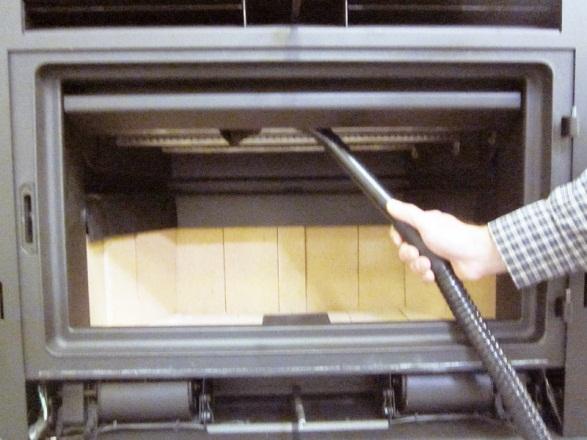 With the stove fully cooled, insert the ash vacuum nozzle into the area