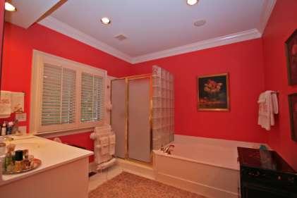 ceramic tile floor; separate shower with ceramic tile floor, accent glass block shower wall and a glass door; separate soaking tub; two raised vanities with cultured marble vanity tops, one with a