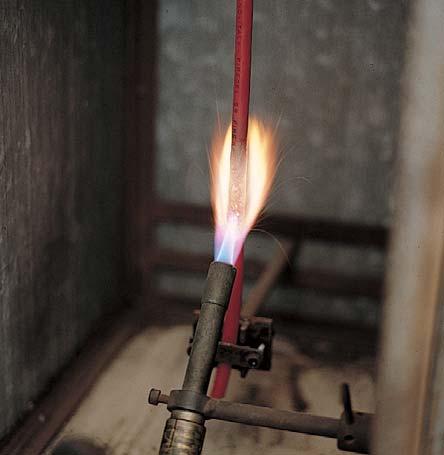 of finished cable is clamped vertically in a threesided metal screen, and a flame is applied for about 60 sec (for max 20 sec for