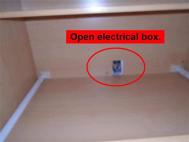 There is an open electrical junction box located on the back wall of the garage. Open and exposed electrical is considered dangerous until corrected.