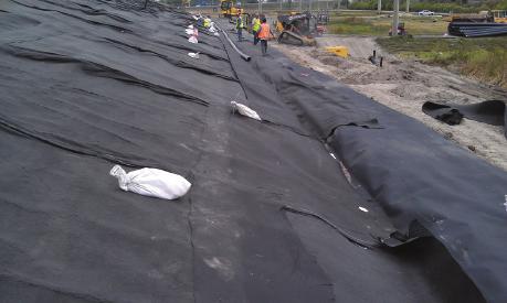 Photo 5: The RTDS geotextile and pipe are positioned. Photo 6: The pipe is encased in gravel. Photo 7: Then wrapped in geotextile is sewn, creating an RTDS burrito.
