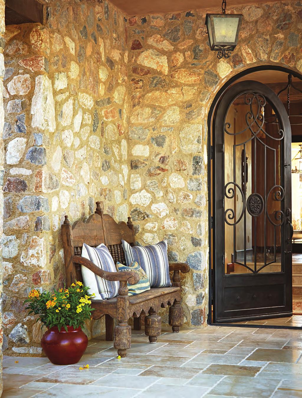 Native cobblestones applied to exterior walls and hand-forged ironwork on the door instantly age this new Arizona