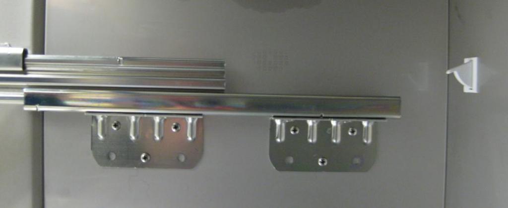 It can be reached from the top of the appliance by first removing the hinge protecting plate.