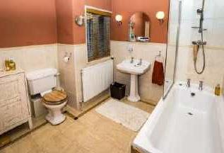 00m) Having three-piece suite comprising panelled bath, pedestal wash handbasin, and low-level WC. Also having window to the rear.