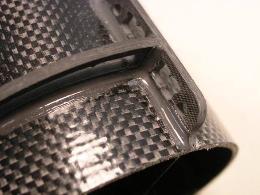 The rear edge of both flanges is flush with the rear edge of the shroud.