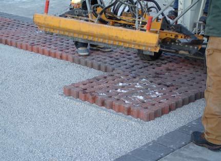 Once the pavers are in place, they openings are filled with the small CA-16 stones. Figure 8 shows this process.