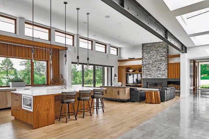 Antiqued exposed beams run the length of the house and book-matched walnut walls and locallysourced ledgestone soften the angular modern elements.