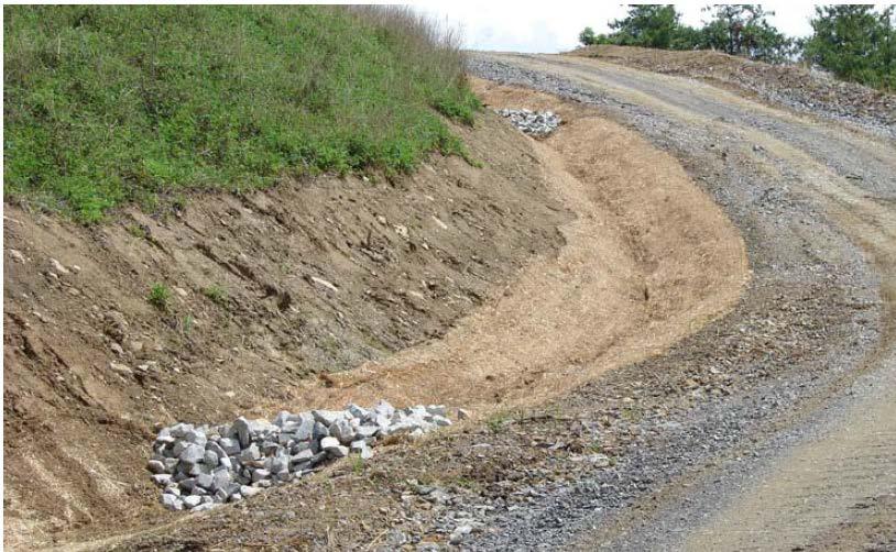 ROCK DITCH CHECK DAMS Small temporary stone dams constructed across a ditch used to reduce the velocity of storm water flows, thereby reducing