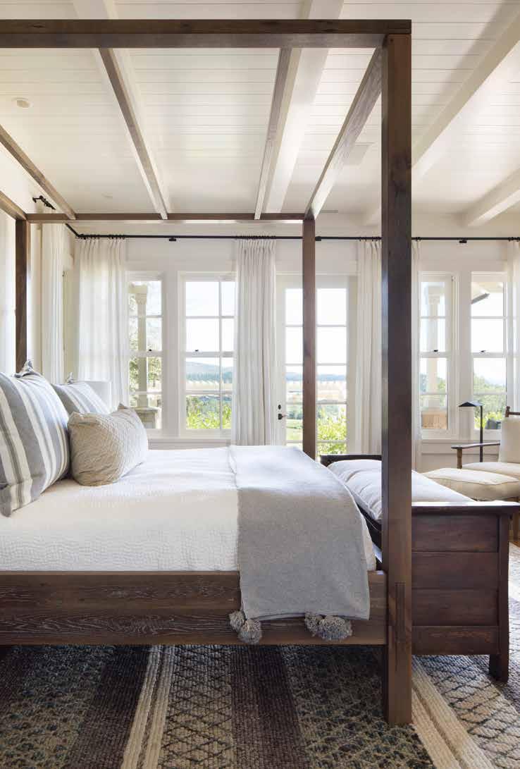 The reconfigured master bedroom suite features a rustic canopy bed. At the end of the bed, a bench from Briggs House of Antiques provides functionality.