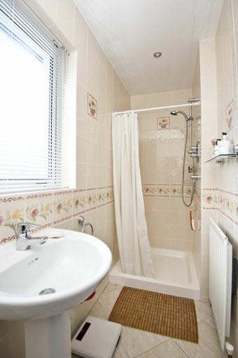 24m) ENSUITE SHOWER ROOM: Comprising tiled shower with chrome fittings, low flush wc, pedestal wash