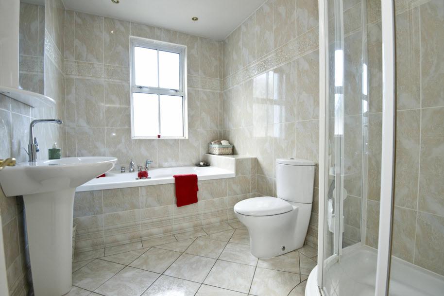BATHROOM: Modern white suite comprising Jacuzzi bath with retractable shower.