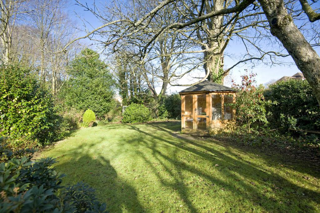 FRONT GARDEN: Lawn with well-stocked beds featuring superb variety of mature plants, trees