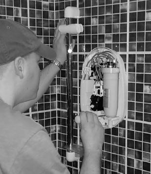 Q9.An electrician is replacing an old electric shower with a new one. The inside of the old shower is shown in the figure below.