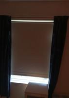 Cream roller blind and blue curtains on a plastic rail. 54.57965659111871, -5.