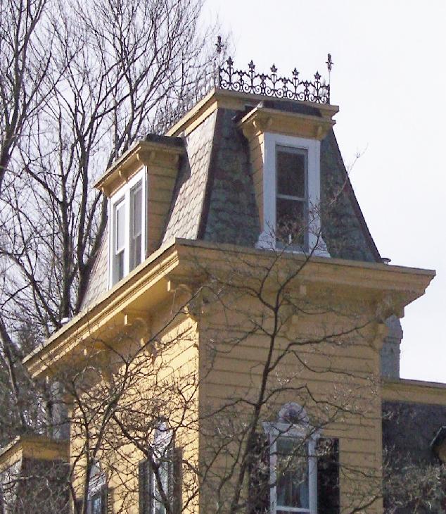 Cast-iron cresting Tower with straight sided mansard roof and dormers Overhanging bracketed eaves Mansard roofs, straight or concave profile; originally patterned gray slates with colored slate
