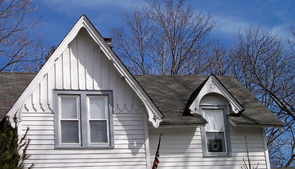 batten siding Gable wall dormer with bargeboard Bargeboard with cutouts Gable and cross gable roofs; gable dormers; overhanging eaves with braces or decorative trim along eaves or in the gable peak