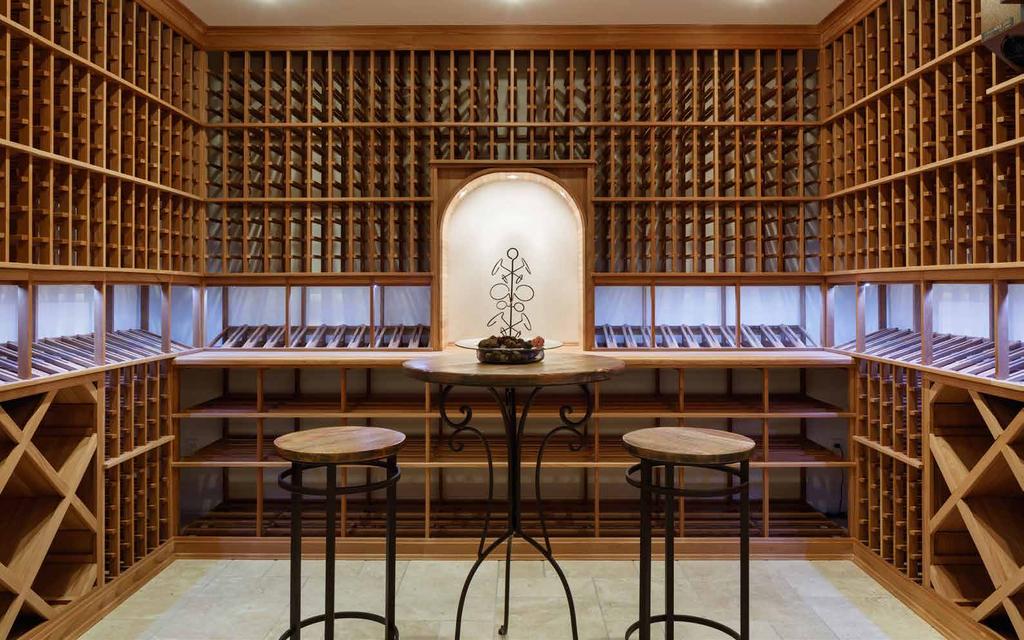 WINE CELLAR Custom temperature-controlled wine cellar with tasting area, beige slate floors,