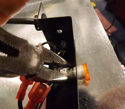 Use needle nose pliers to squeeze the tabs on the indicator light while pushing it out through the bracket (Fig.