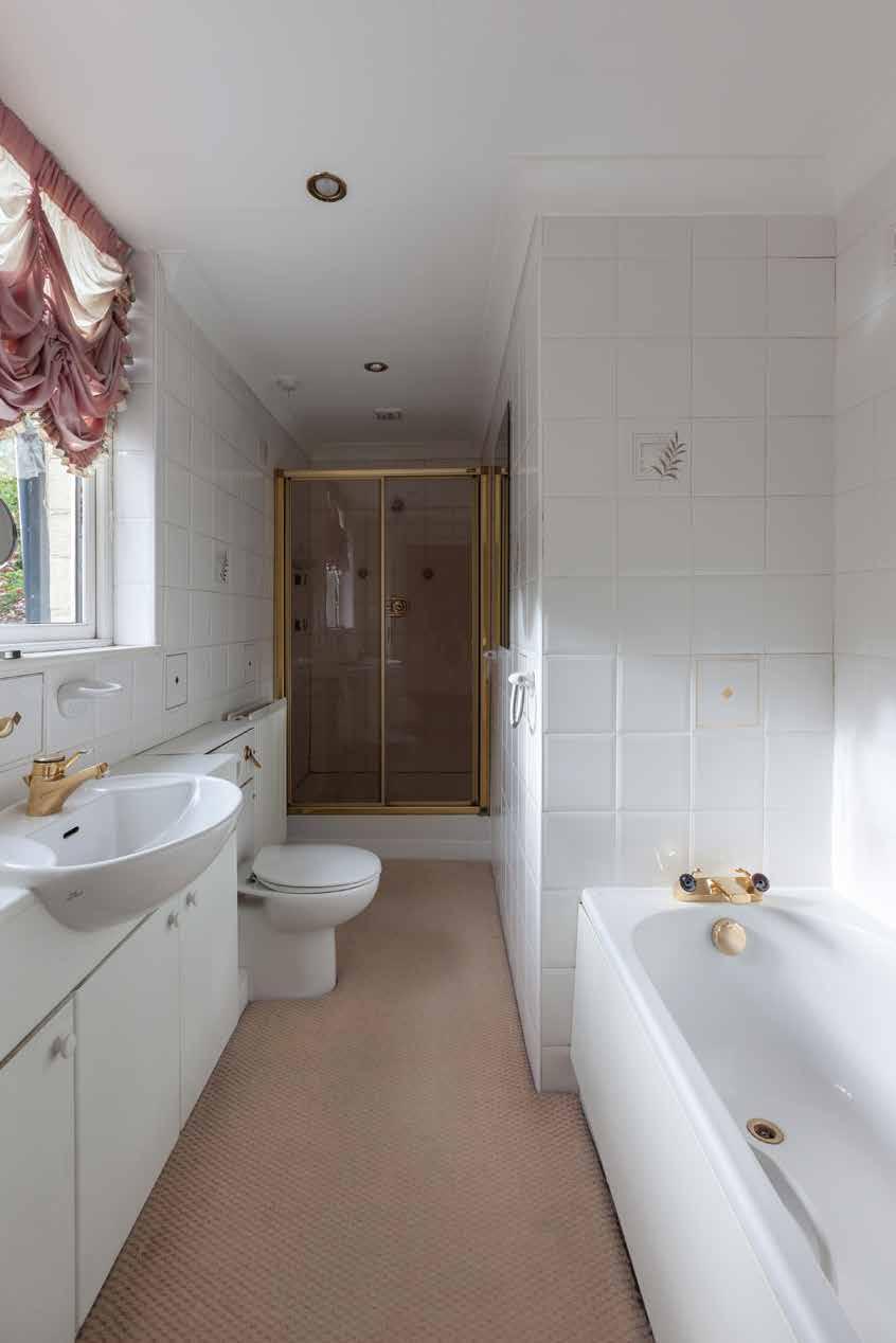 En-Suite Bathroom With a rear facing timber double glazed window, recessed spot lighting, tiled walls and a suite in white comprising a low level WC, panelled bath, wash hand basin with
