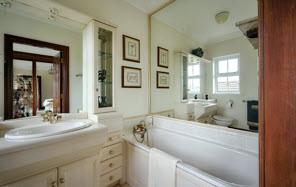 BATHROOM: White bathroom suite comprising panelled bath, fully tiled built-in shower