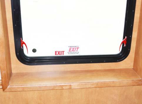 Escape Window (Lift both red safety latch handles UP and push window OUT) EMERGENCY EXITS Escape Window The escape window is secured by two red safety latches at the bottom or side of the