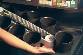 Loosen the 3 thumbscrews by hand that hold the cup conveyor cover in place by turning them