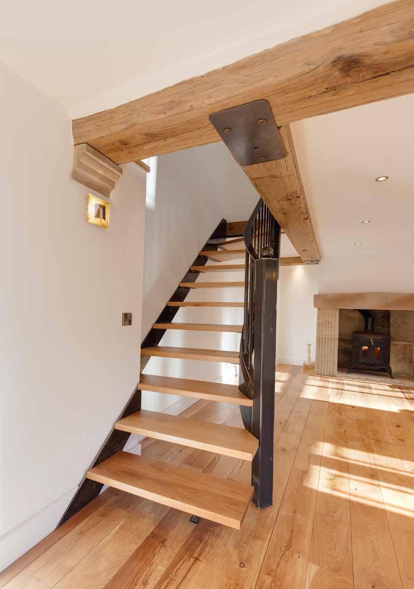 A contemporary sweeping staircase with open burnished steel rails and risers with matching solid oak treads leads from the living room up to the First Floor.
