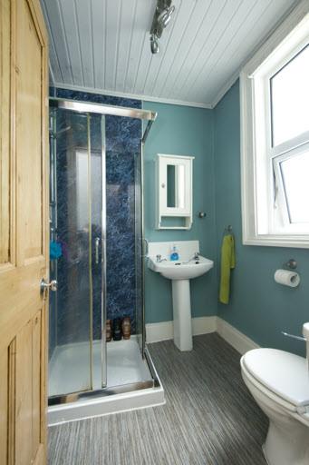 SHOWER ROOM: Shower cubicle with thermostatically controlled mains shower, low flush wc, pedestal wash