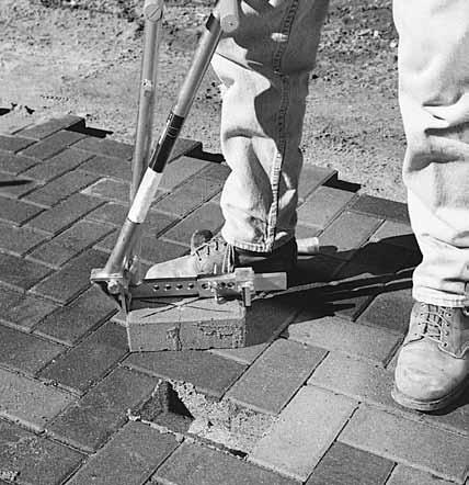 Figure 2. Removing joint sand surrounding the first paver to be removed. Figure 3. Prying the paver upwards with two large screwdrivers. Figure 4. Prying with a screwdriver and pulling the paver out.