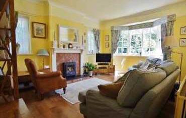 The sitting room features an inset multi-fuel burner complete with a tiled surround and stone hearth and is showered in natural light, by way of a large bay window which also provides views over the