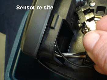 The lugs to the left of the white connector fit in the large hole to the left with the two