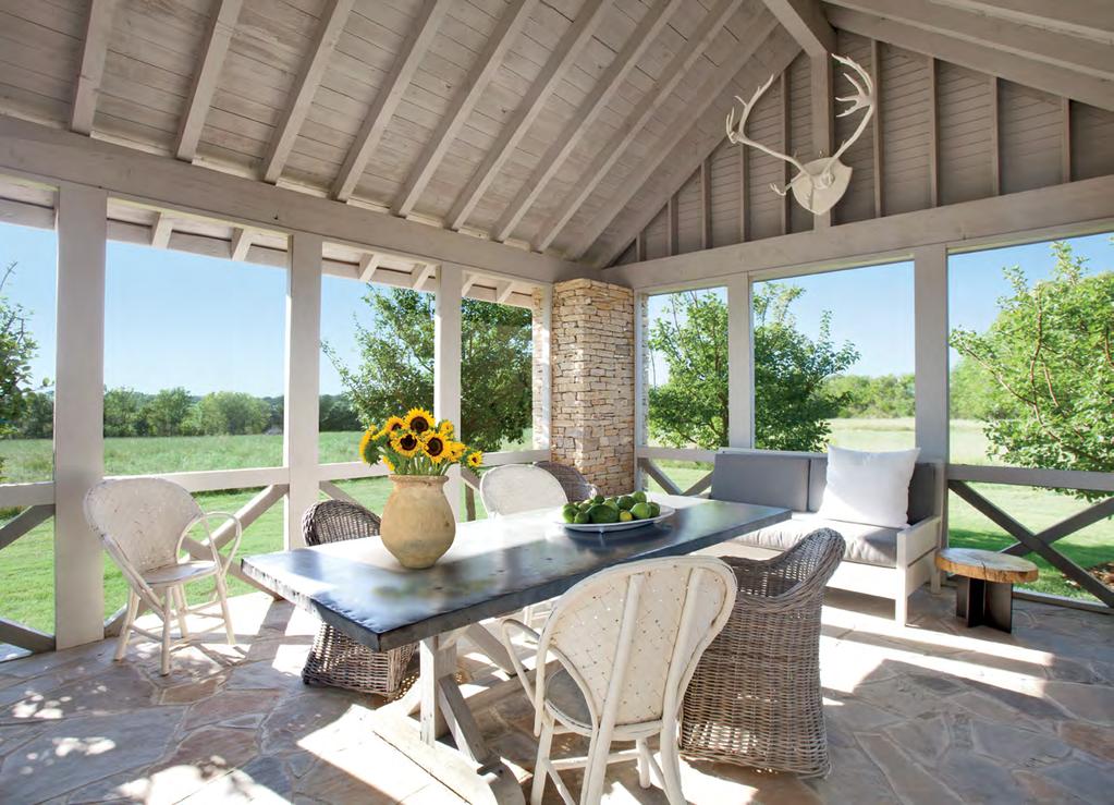The screened porch features a Belgian zinc-topped table with a bleached-pine base;