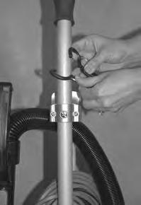 Pull apart the rounded end of the cord retainer to open it up enough to fit around the vacuum handle (Fig. 3). 2.