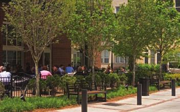 This landscape provides a comfortable, safe, and aesthetically pleasing pedestrian environment. A railing separates the outdoor dining area from the busy street.
