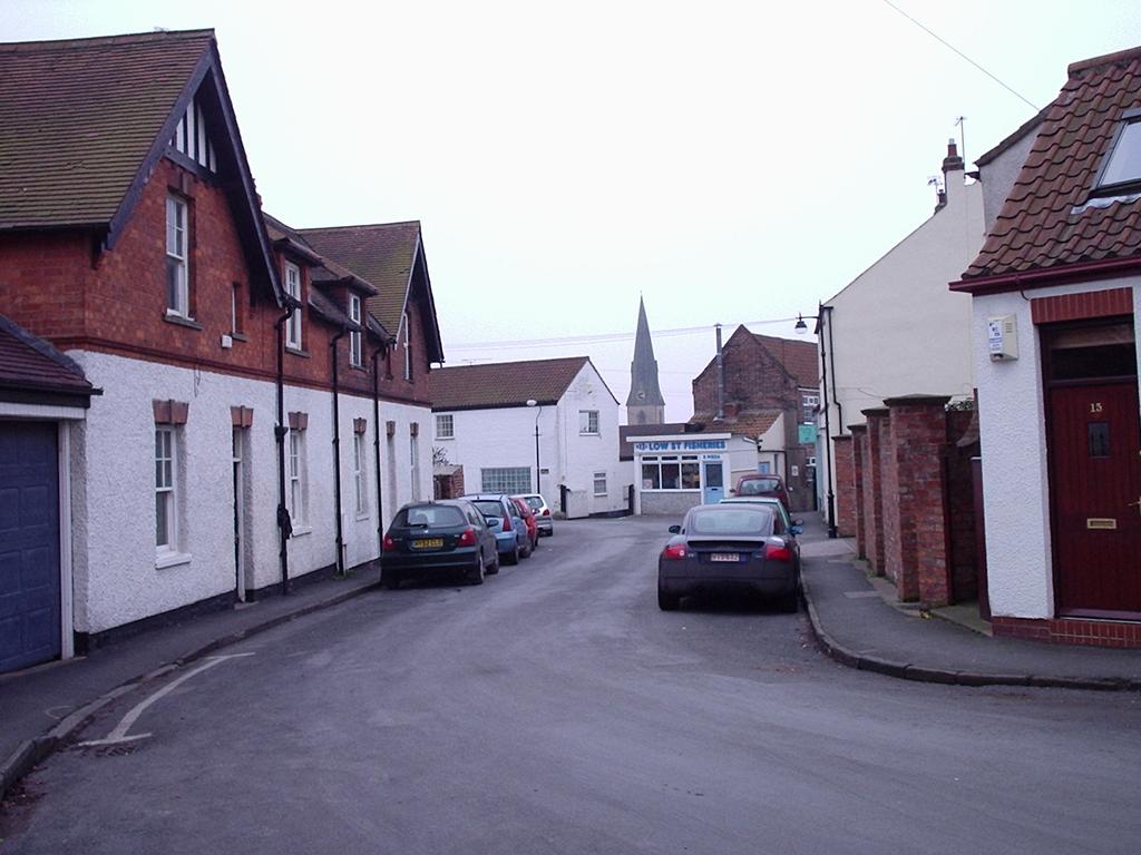 properties along Station Road and the mixture of soft landscaping (including grass verges) along Narrow Lane. View from outside The Royal British Legion looking south.