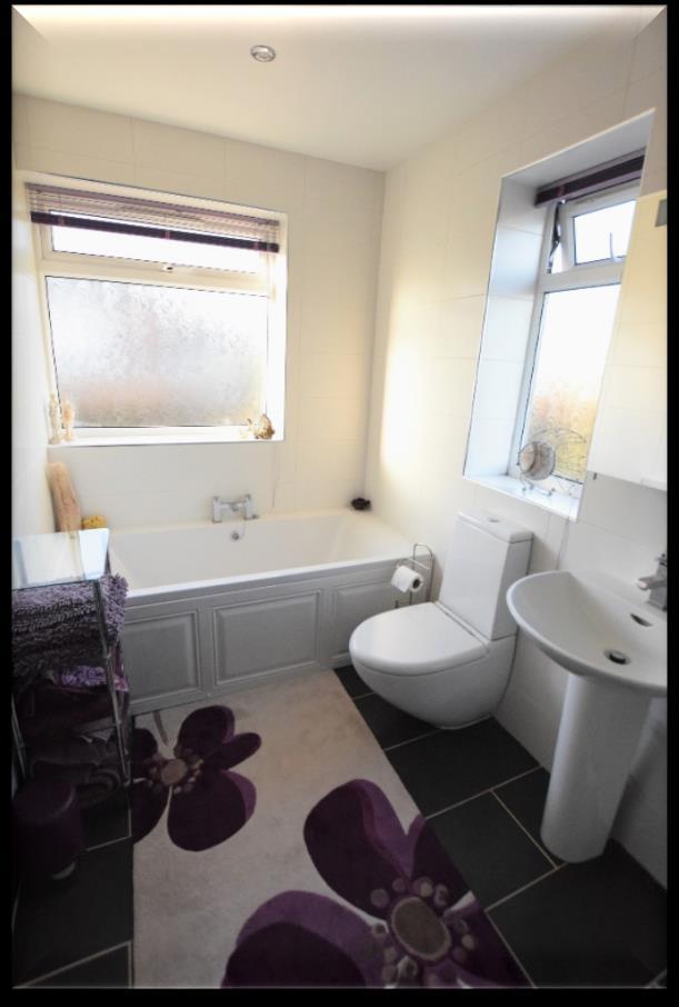 tiled floor, feature heated towel warmer/radiator, inset LED spotlights, extractor, two upvc double glazed windows with frosted glass having fitted blinds