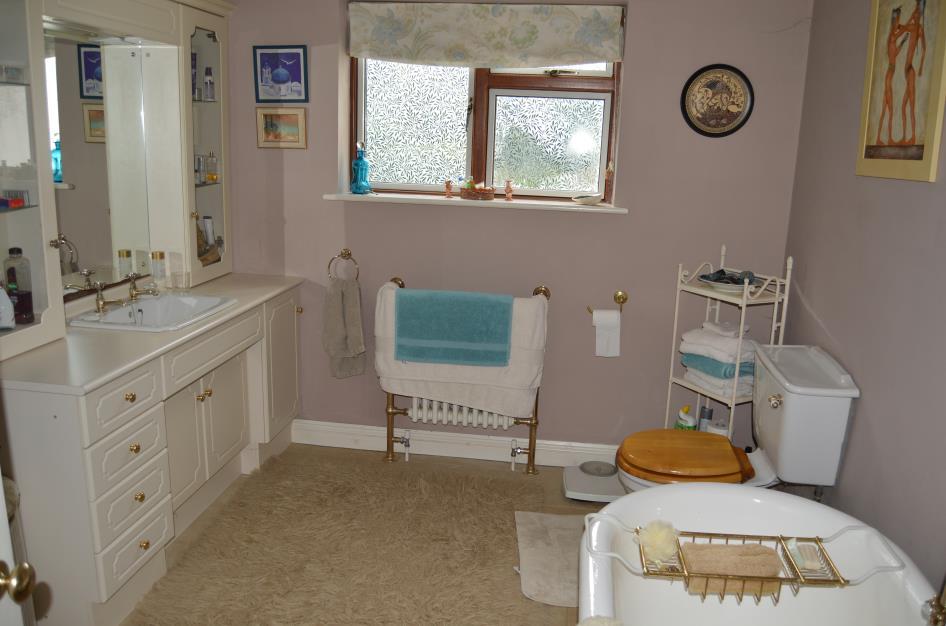 En Suite Bathroom: with ceramic tile floor covering, crow foot bath with mixer tap and telephone handle shower attachment, low flush w/c, towel rail/radiator, vanity unit with mounted