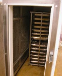 removed through the exit door at the other end. Note evaporator coil and fans (covered by mesh) on left hand side of trolley. Figure 1.
