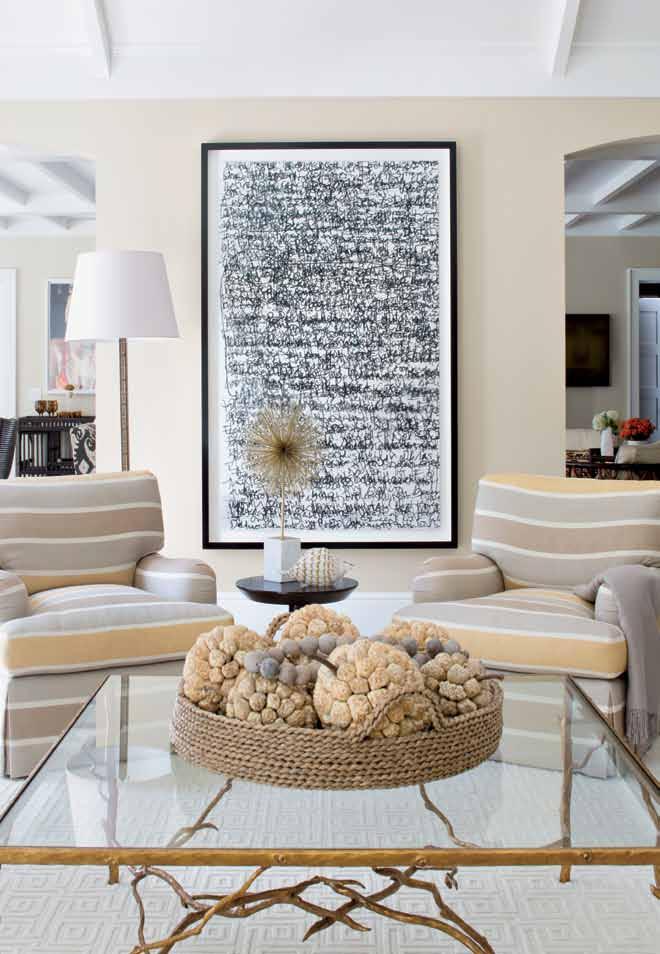 Light tones give the living room an inviting feel. A coffee table with a gilded branch base by Paul Ferrante centers the room.