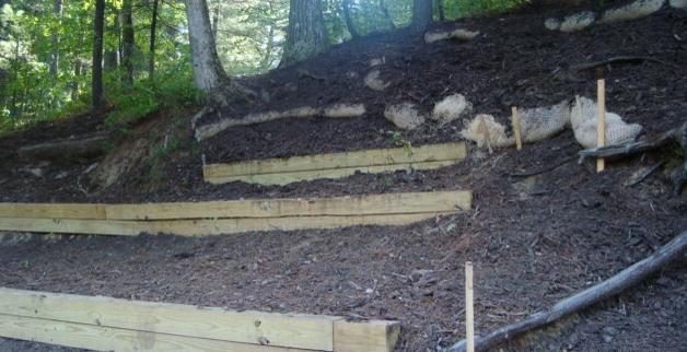 The photo (below) displays the large timber waterbars, fiber rolls, erosion control mulch, and