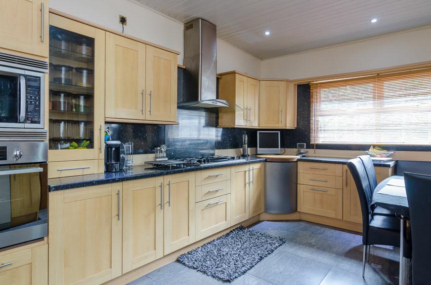 66m) Extensive range of high and low level units, work surfaces with tiled panelled splash back, 1 1/2 basin sink unit with mixer tap, glass display cabinets,