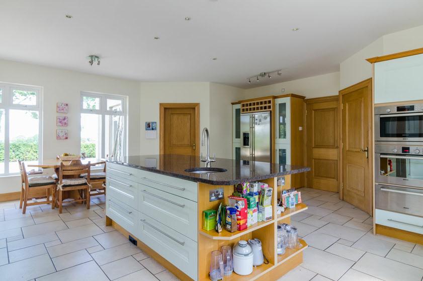 display cabinets, housing for American fridge freezer, cooker range with 6 ring gas hob and multi ovens with splash back and ornamental surround.