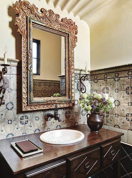 OPPOSITE: Reclaimed-limestone floor pavers in the master bath supply a rustic counterweight to glazed tiles that were individually set to create the wainscoting s herringbone pattern.