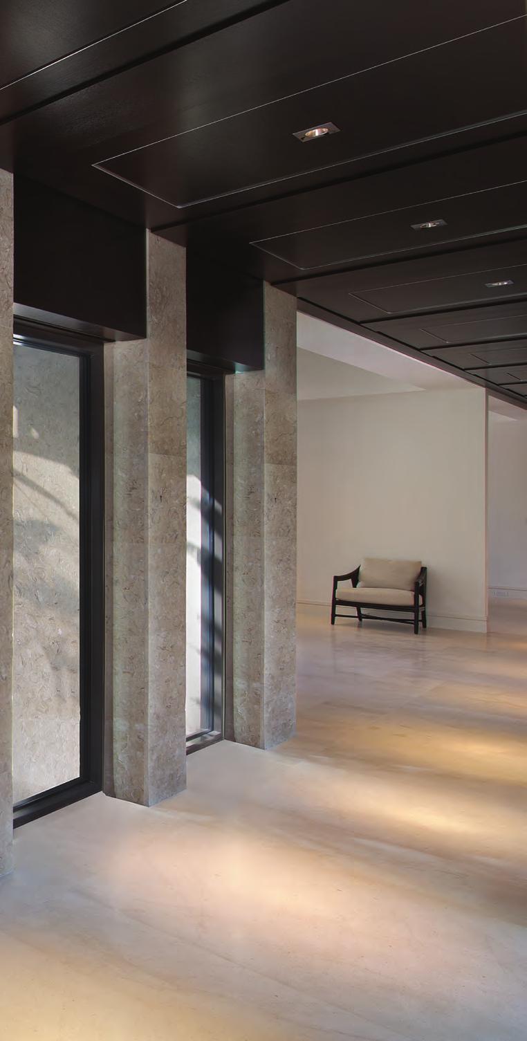 GRAND DETAILING Stone columns are integrated with rich, dark woodwork in the expansive gallery that greets visitors to